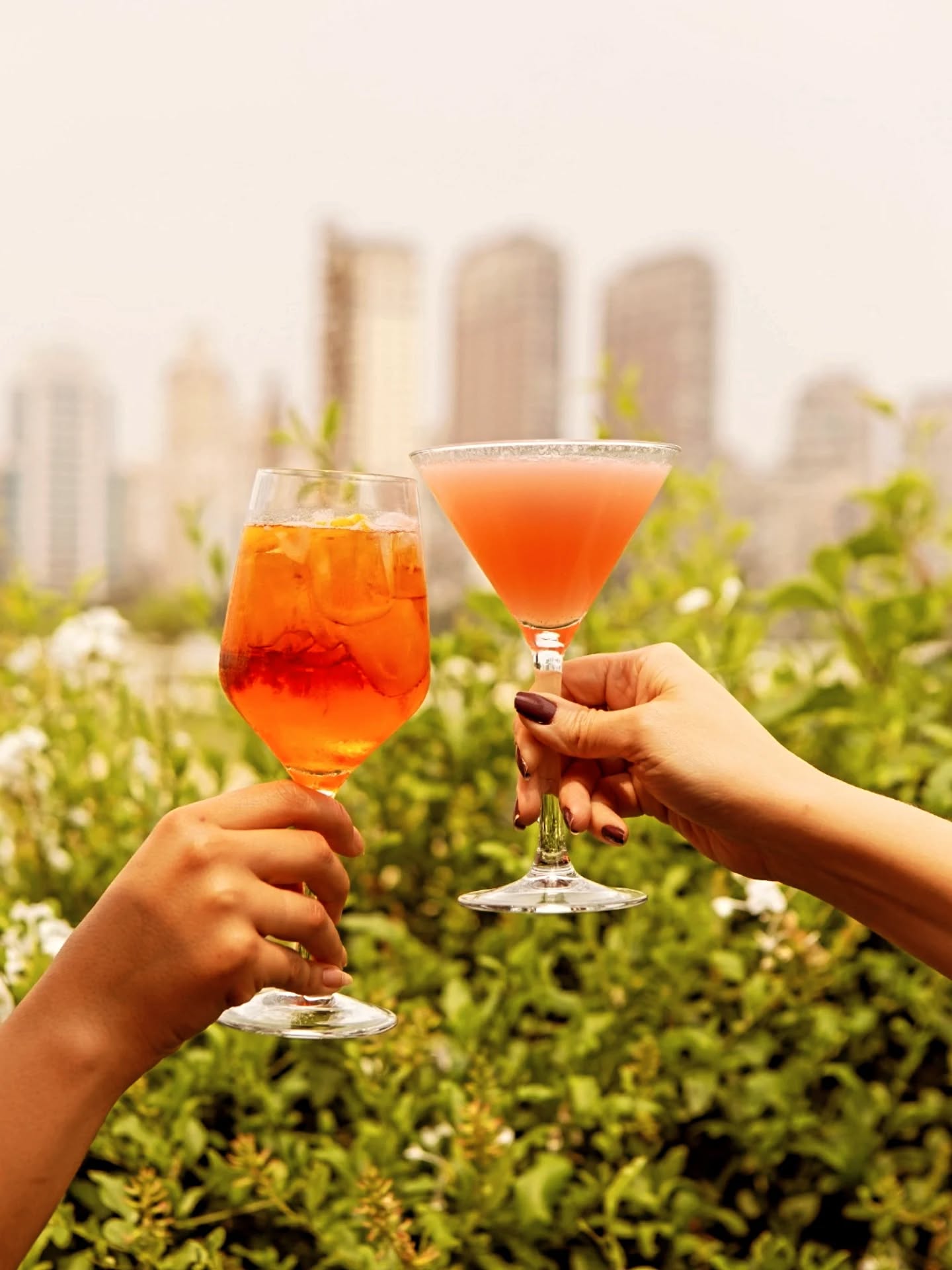 Un brindis con cócteles y el skyline de São Paulo al fondo