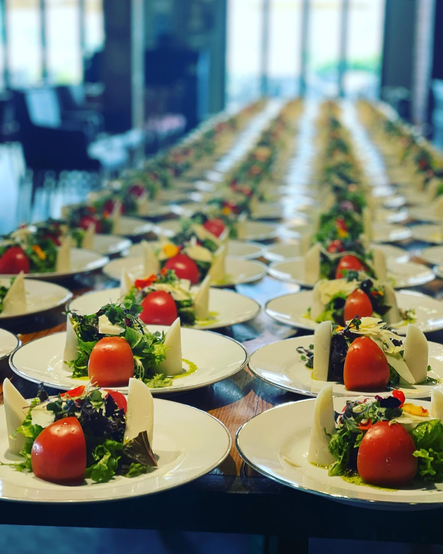 Una mesa larga dispuesta con entradas de tomate y mozzarella
